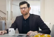 a person sitting at a table with a mug and food